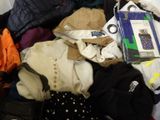 a pile of clothes that is sitting on a bed