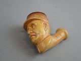 a small pipe with a man ' s face on it