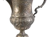un vase en argent richement décoré, muni d'un couvercle, sur fond blanc