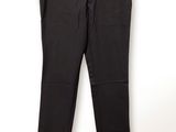 un pantalon noir suspendu à un cintre devant un mur blanc