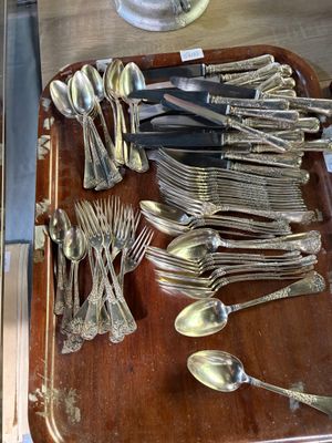 de nombreuses cuillères et fourchettes posées sur un plateau posé sur une table