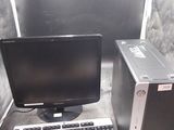 un ordinateur de bureau posé à côté d'un clavier et d'un écran