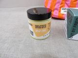 a jar of cream sitting next to a bag on a couch