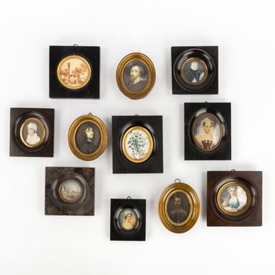 Plusieurs portraits encadrés de personnes sont accrochés au mur.