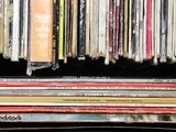 a lot of cds stacked on a shelf in the room