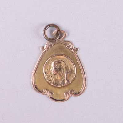 une médaille d'or avec la photo d'une femme dessus