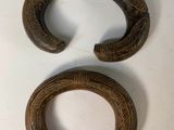 two pieces of carved wood sit next to each other on a table