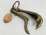 an image of a cork opener with a walnut in the background