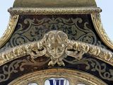 a gold clock with a blue and white design on it