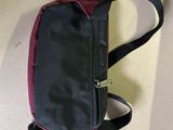 a black and red bag on the floor with a tag attached to it