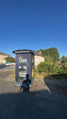 a trash can sitting on the side of the road