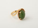 a close up of a ring with a green stone on it