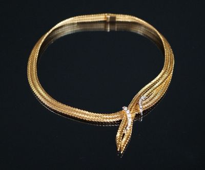 un gros plan d'un bracelet en or orné d'une tête de serpent
