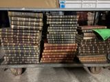 de nombreux livres anciens empilés sur un chariot dans le magasin