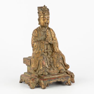 une vieille statue en bronze représentant un homme assis sur un banc