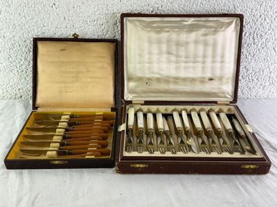 deux sets d'argenterie dans un coffret sur une table