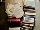 a pile of books sitting on the floor next to a laptop
