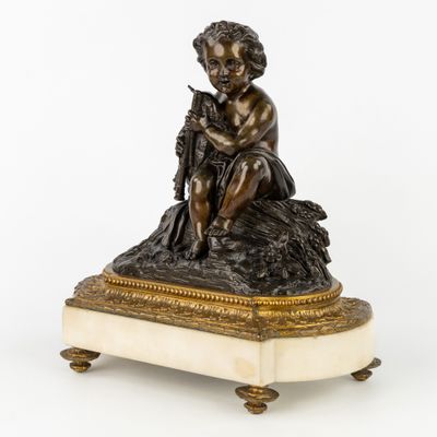 une figurine antique en bronze représentant un garçon assis sur un rocher