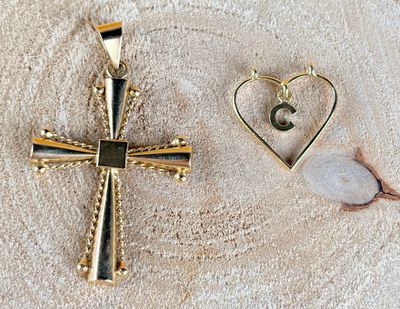two gold cross pendants with a heart and a letter c