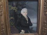 tableau représentant un homme en costume noir, muni d'une canne, dans un cadre doré