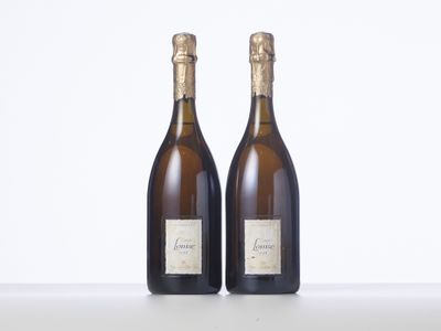 two bottles of wine sitting on top of a table next to each other