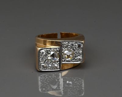 a close up of a gold and diamond ring on a reflective surface