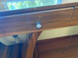 a wooden desk with a glass top and a drawer