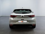 the rear end of a silver car in a room with a white wall