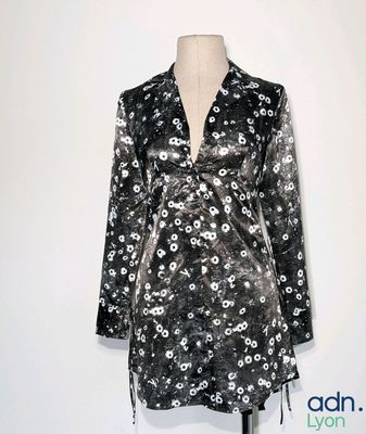 une robe à fleurs noire et blanche posée sur un présentoir pour mannequin