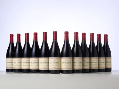 six bottles of red wine lined up in a row on a table