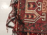 a close up of a red and black rug with fringes