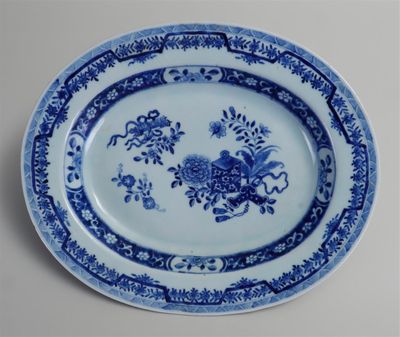 une assiette bleue et blanche ornée de fleurs et d'oiseaux