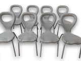 six chaises grises sont alignées en rangée sur un fond blanc