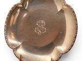an antique silver plate with a decorative design on the rim