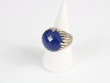 a close up of a ring with a blue stone on it