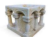 a white marble altar with four pillars and a cross on top