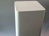 a white vase sitting on a table next to a black vase