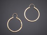 a pair of gold hoop earrings on a black background