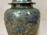 un vase en argent muni d'un couvercle, sur fond blanc