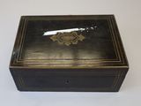 an old black box with a gold design on the lid