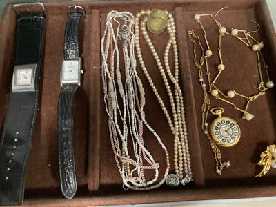 un coffret en bois contenant une montre, des bracelets et d'autres bijoux