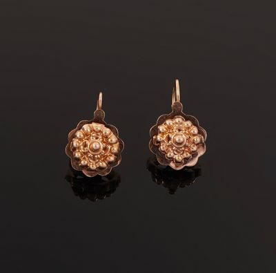 a pair of gold earrings with a flower design