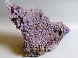 a small piece of purple stone on a white surface
