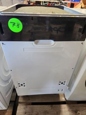 un lave-vaisselle blanc sur lequel est collé un autocollant vert