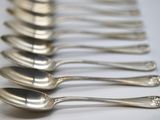 several spoons are lined up in a row on a white surface