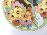 a colorful plate with a bird and flowers on it