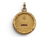 une médaille d'or ornée d'une croix et d'une pierre rouge au centre
