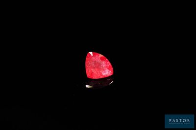 a close up of a red diamond on a black surface