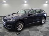 un SUV Jaguar bleu garé dans un showroom au sol carrelé