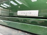 a close up of a green car with a ruler on it ' s bumper